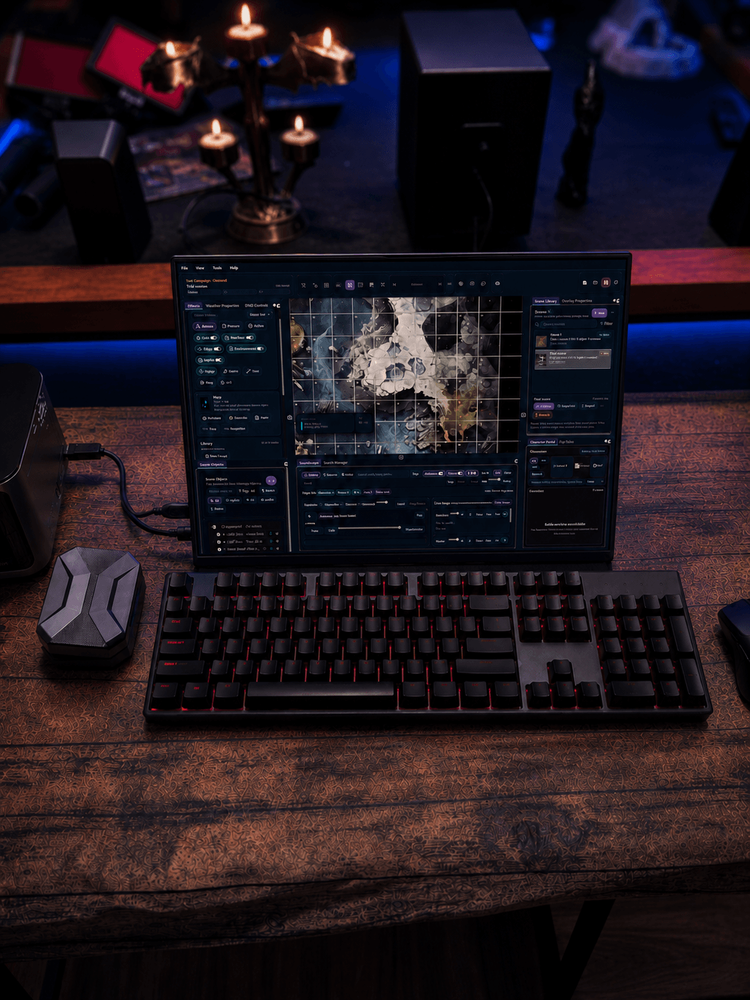 Laptop displaying the TabletopFX Game Master interface with a grid-aligned battlefield preview.