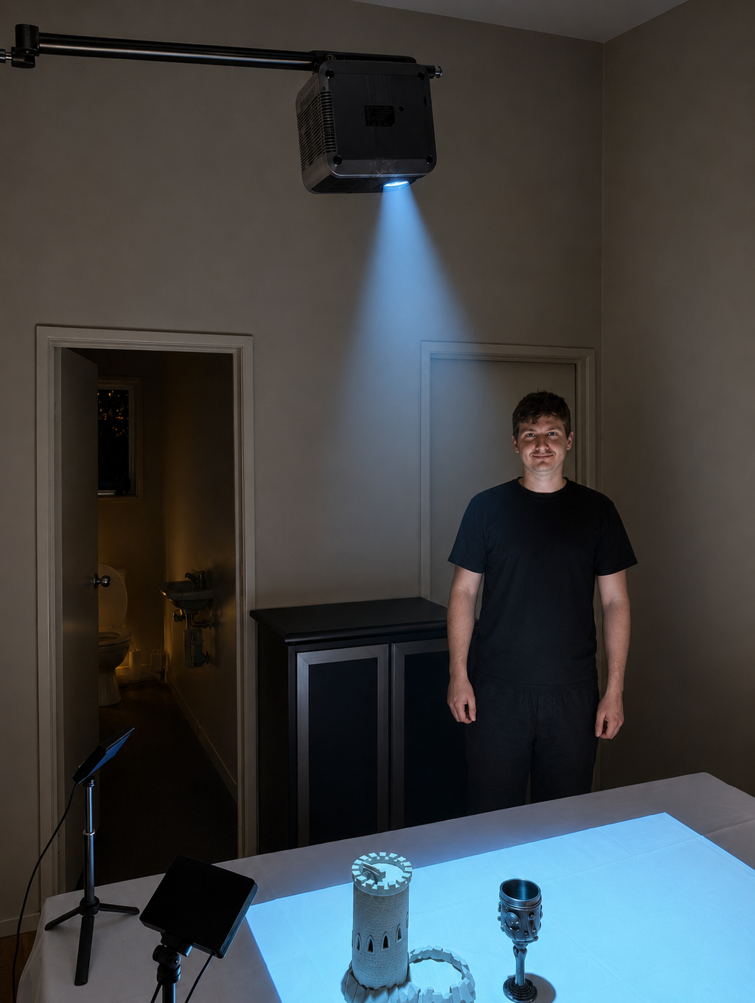 Projector-lit studio tabletop with 3D terrain objects and miniatures